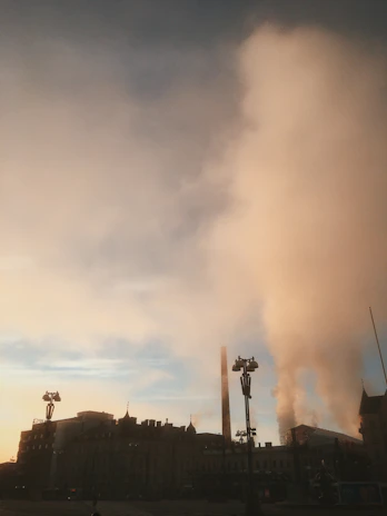 A detailed air dispersion model map showing pollutant spread over a cityscape at sunset.