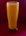 A tall glass of cold-pressed orange juice with condensation droplets, set against a bright kitchen background.