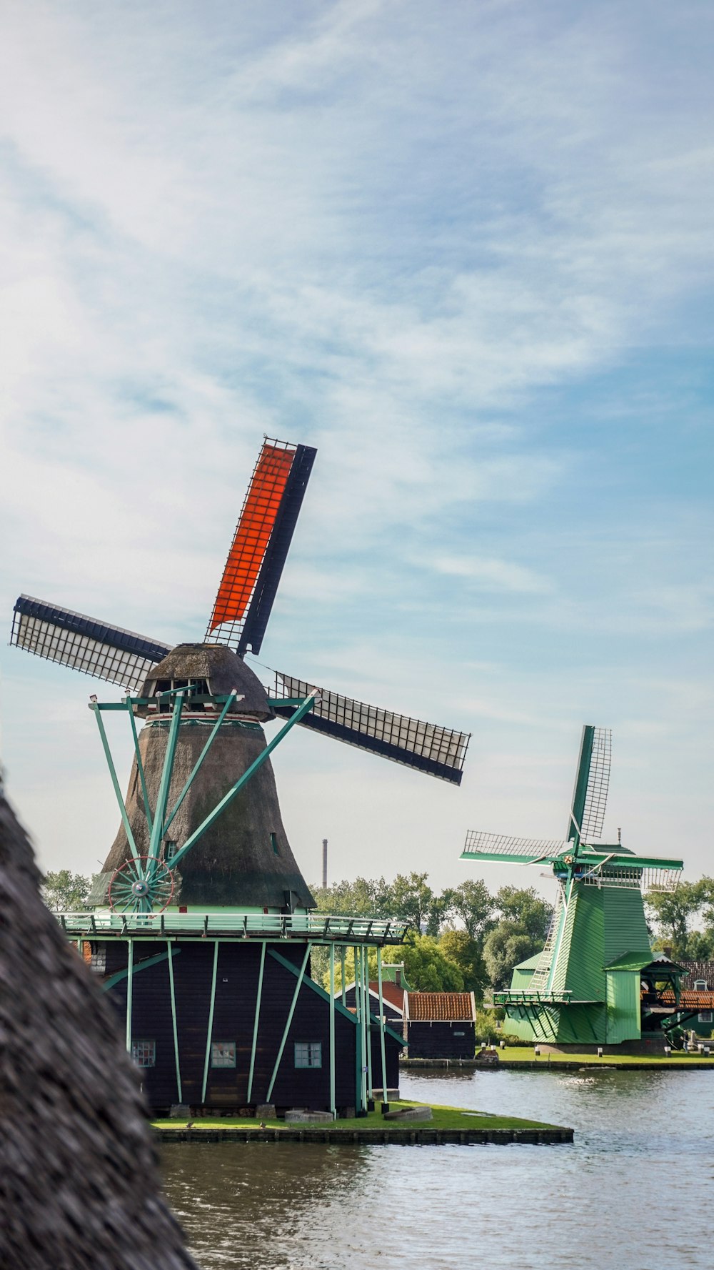 a windmill next to a body of water