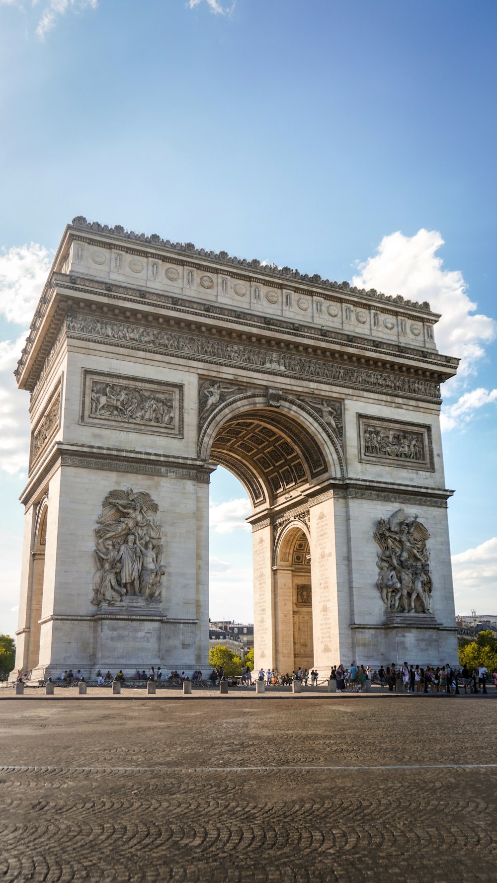 a large stone monument with Arc de Triomphe in the background