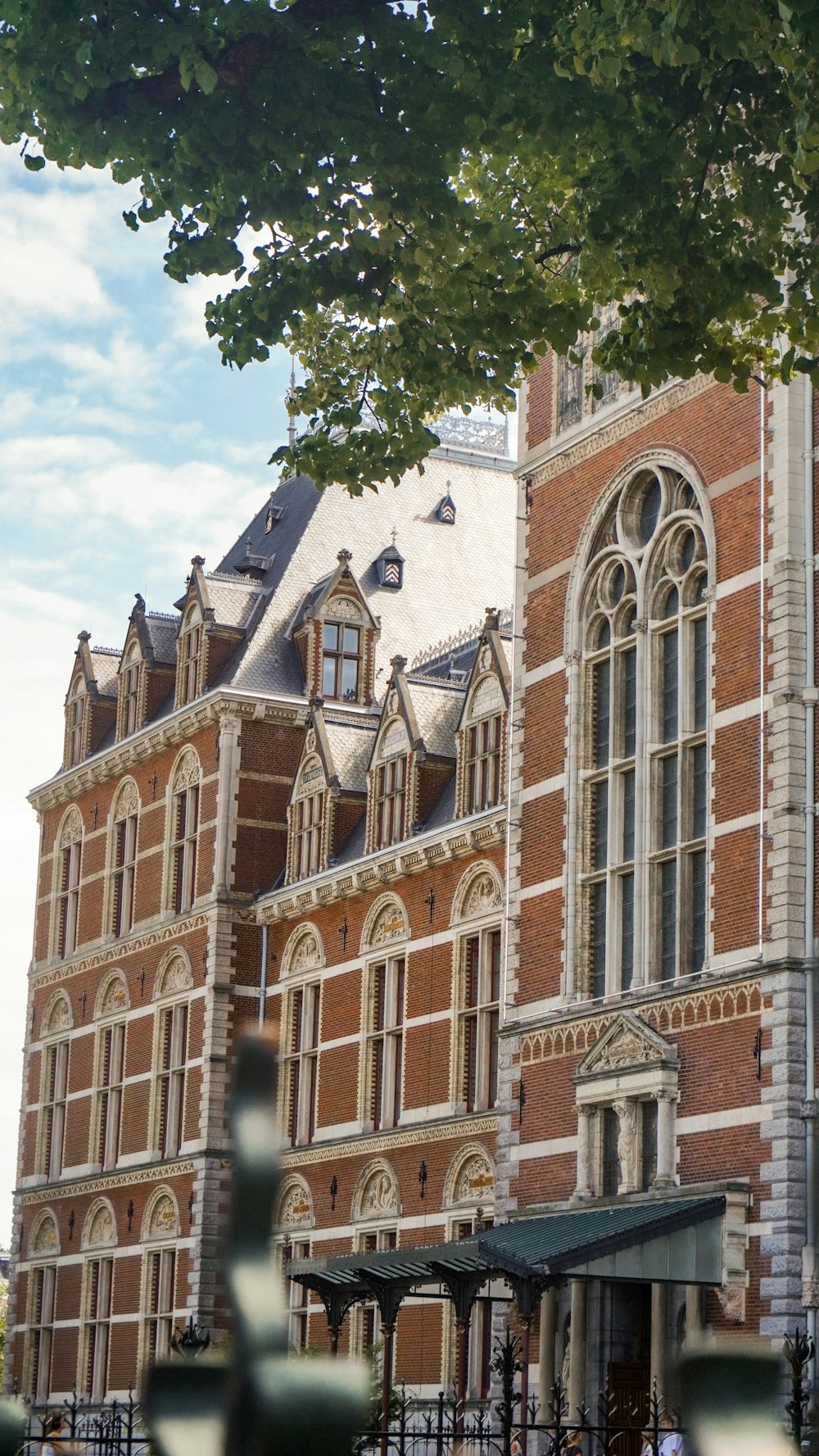 Un edificio di mattoni con un albero di fronte ad esso foto – Amsterdam  Immagine gratuita su Unsplash