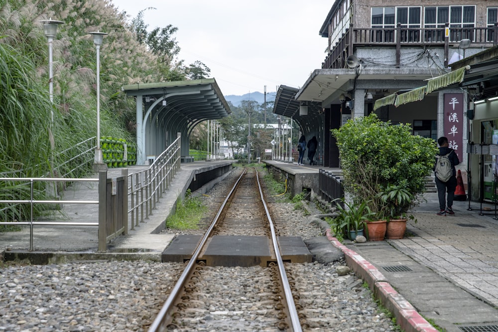 a person standing next to a train track