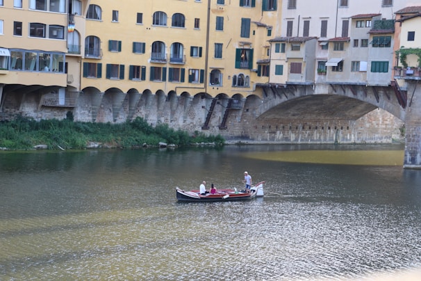 A scenic river cruise passing under ancient stone bridges with a family marveling at the sights from the deck.