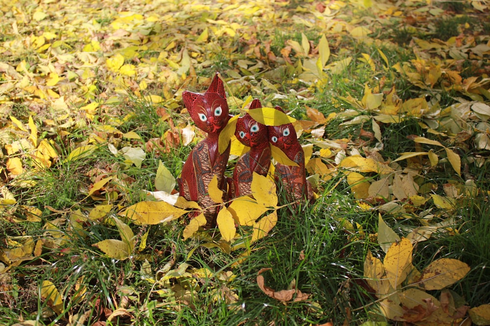 a group of colorful statues in a pile of leaves