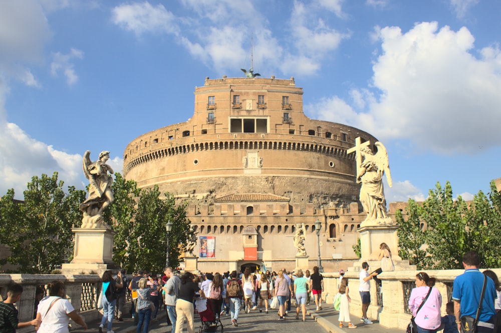 un grande edificio con una statua di fronte con Castel Sant'Angelo sullo sfondo