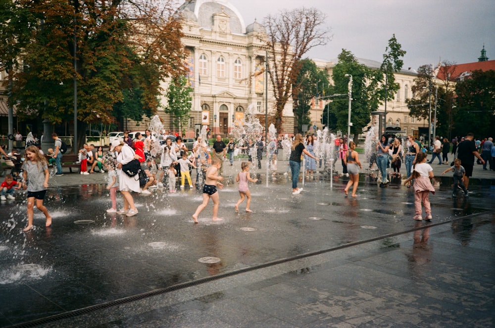 a group of people playing in a water fountain
