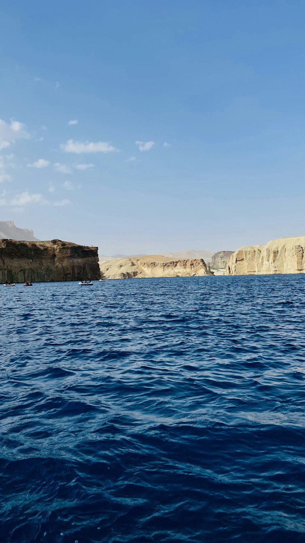 a body of water with a rocky shoreline and blue sky