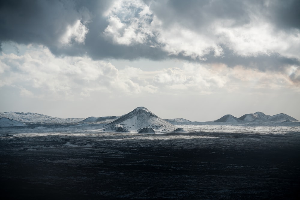 un cuerpo de agua con icebergs y nubes arriba