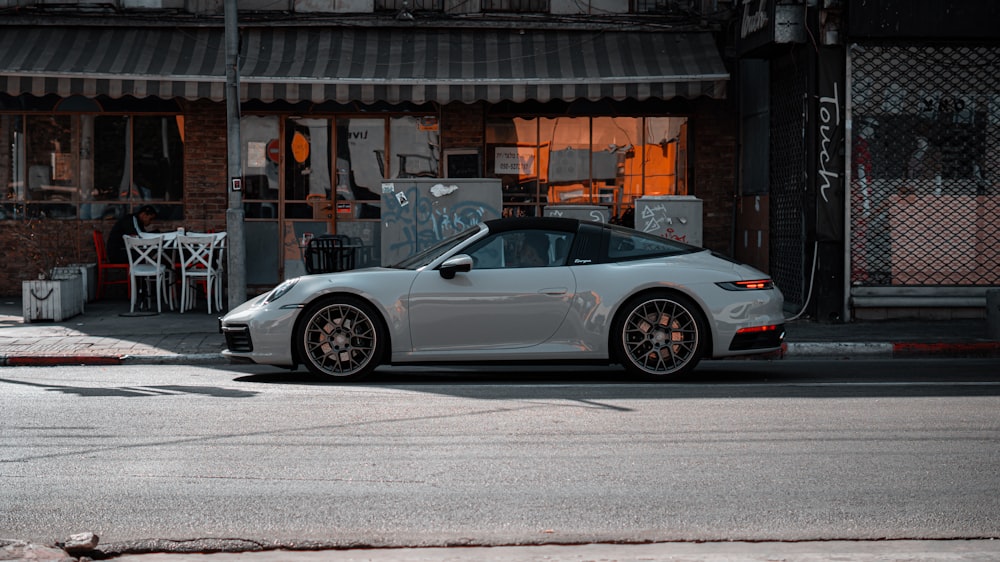 a silver sports car parked on the side of a street