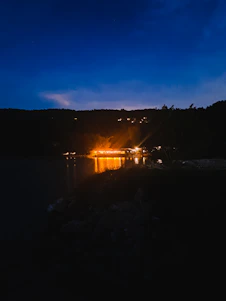A serene night scene with deep blue hues and soft golden light illuminating a vintage microphone beside an open book of poetry.