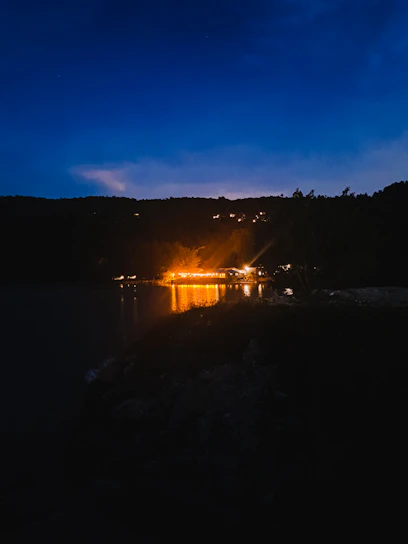 A serene night scene with deep blue hues and soft golden light illuminating a vintage microphone beside an open book of poetry.