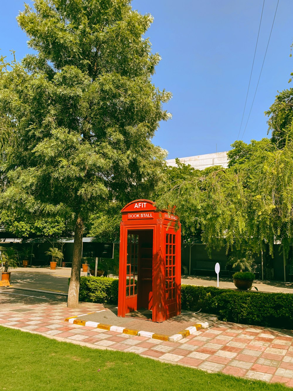a red telephone booth in a park