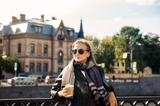 a person holding a drink and standing on a street