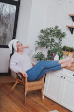 A person peacefully seated inside a cedar steam barrel, head resting comfortably outside.