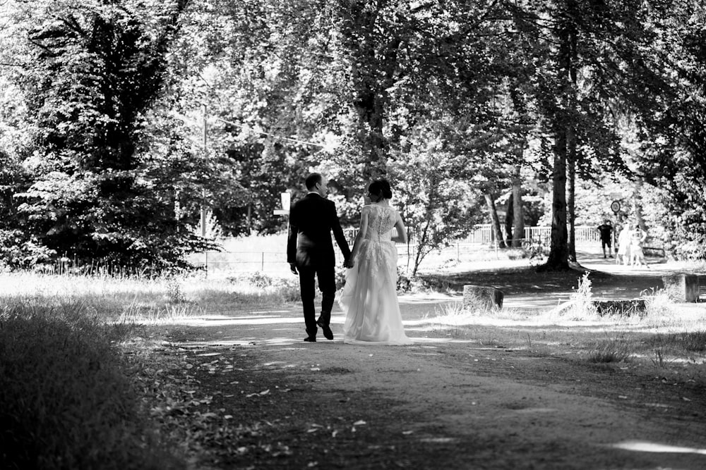 a man and woman walking down a path in a park