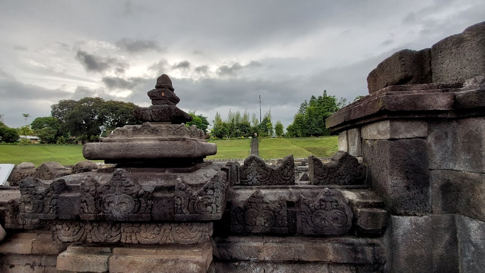 a stone fountain in a park