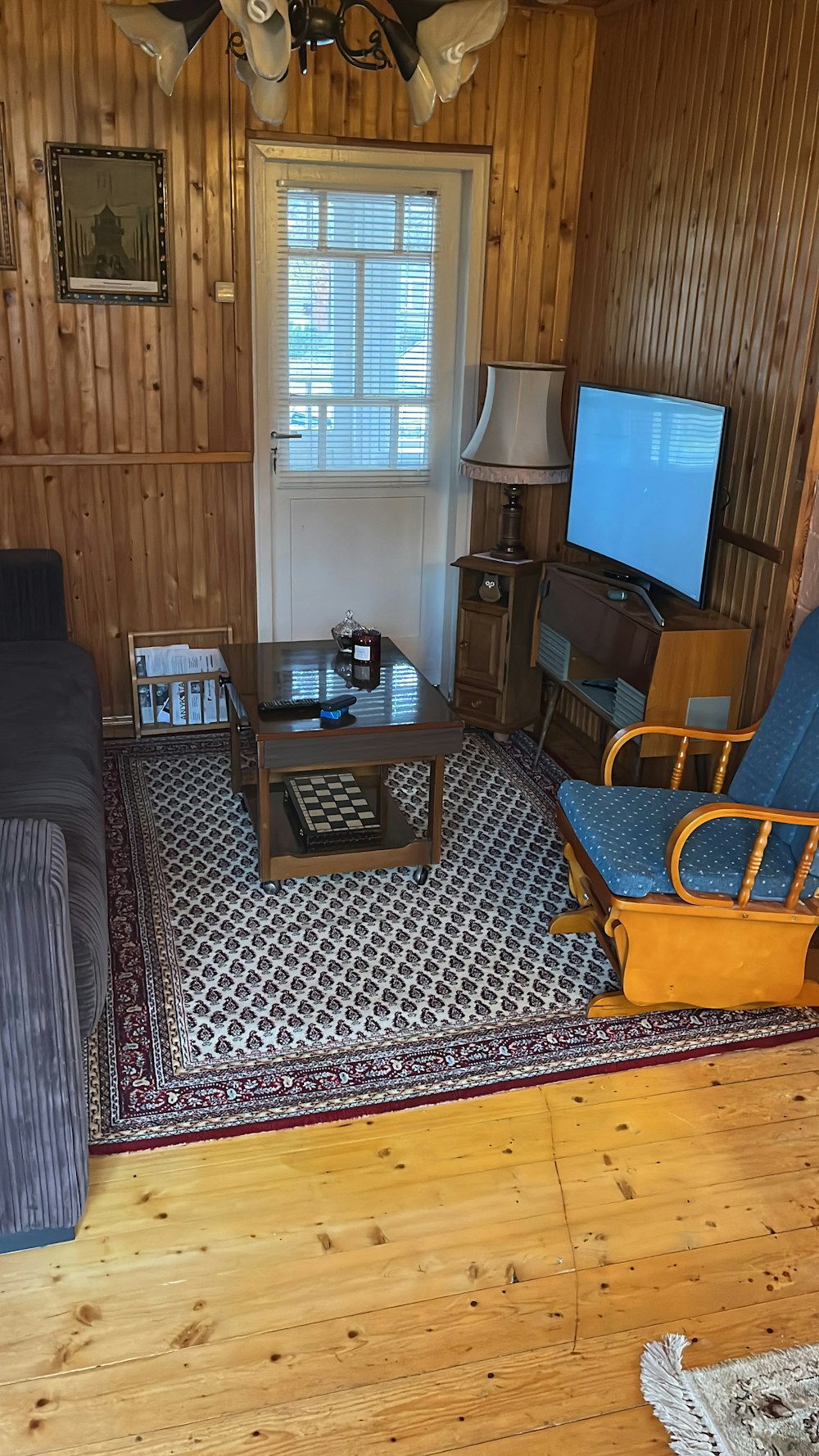 a room with a rug and a table with a tv on it