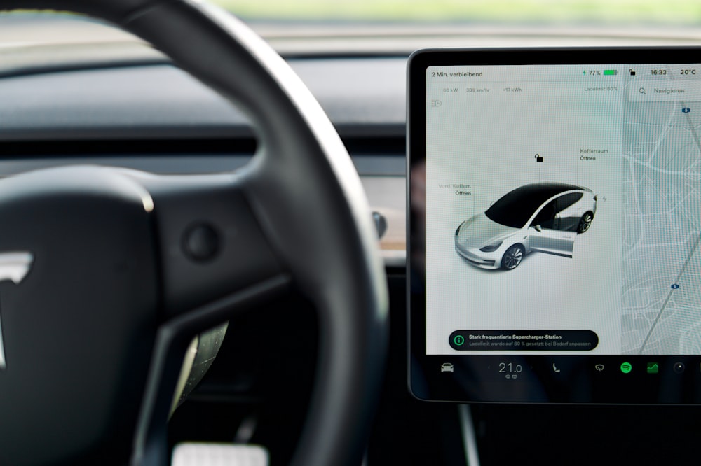 a car dashboard with a screen and a steering wheel