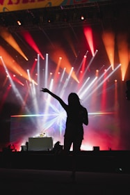 a person on a stage with a microphone and lights