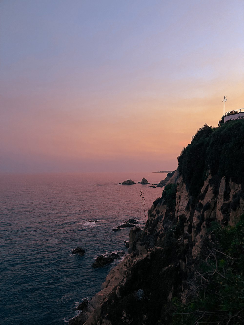 a rocky cliff next to a body of water