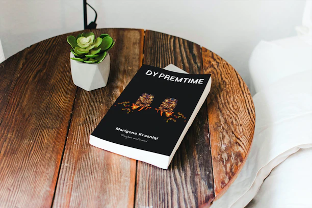 Close-up of a minimalist wooden coffee table with a small plant and a book on top.
