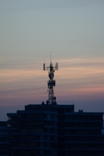 Modern telecommunications tower with glowing network signals at dusk.