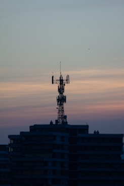 Telecommunications tower with glowing network signals at dusk.