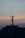 A telecommunications tower is perched on top of a high-rise building against a backdrop of a dusky sky. The sky is painted with gradients of blue and orange, reflecting the transition from day to night.