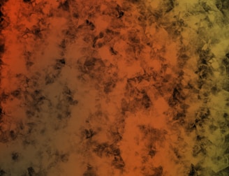 A digital abstract artwork featuring a textured pattern that blends shades of orange, brown, and hints of green. The overlapping shapes create a sense of depth and complexity, resembling a mixture of smoke or layered, translucent materials.