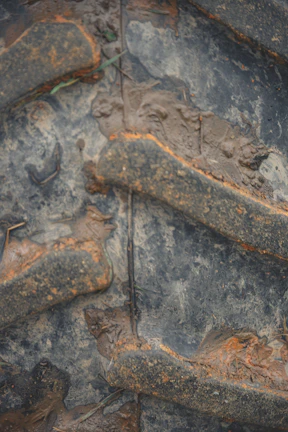 Close-up of rugged machinery tires covered in dirt, emphasizing durability.