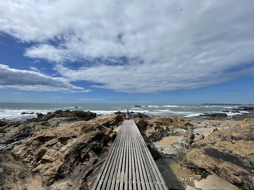 a wooden walkway on a rocky beach