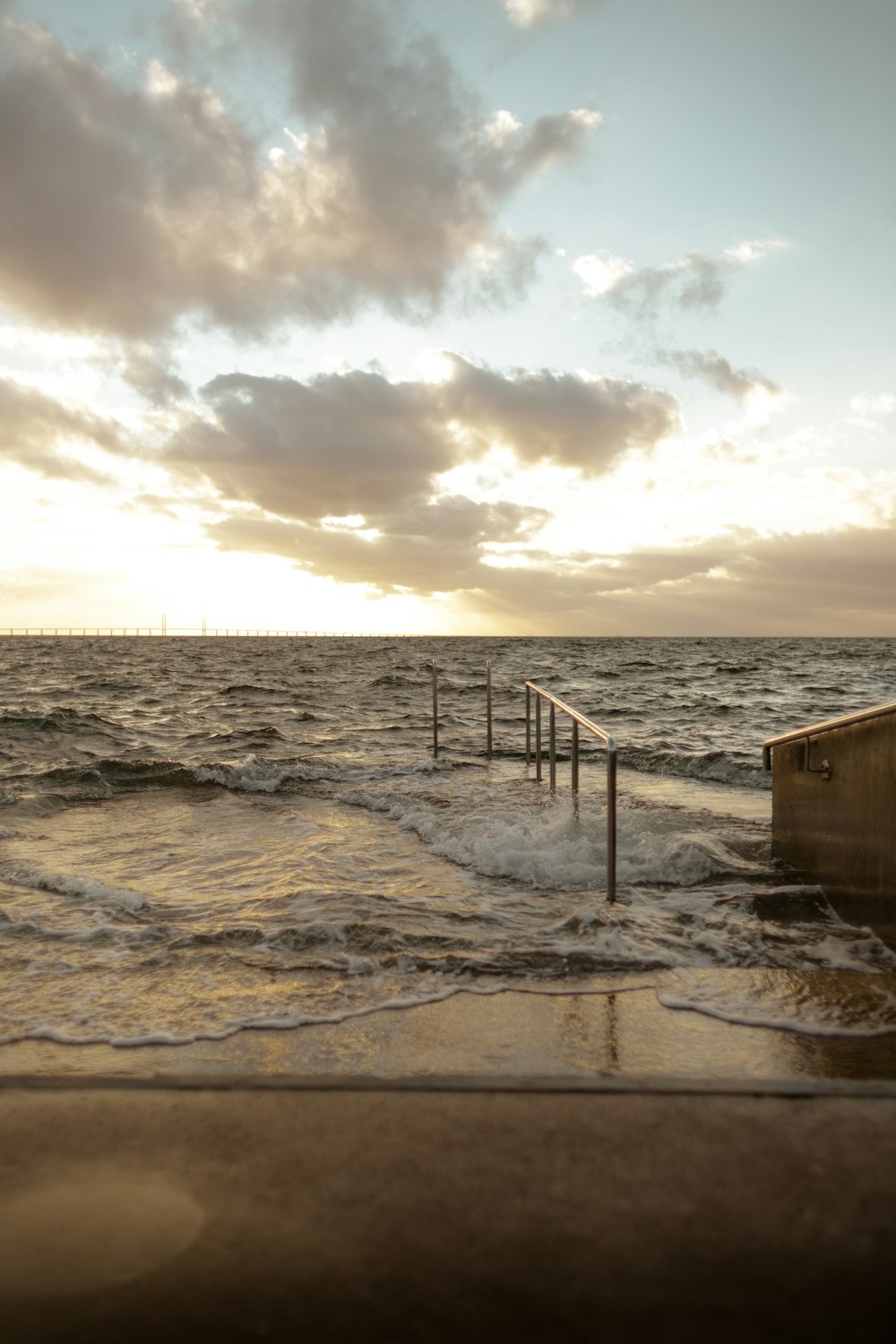 une plage avec une clôture et un ciel nuageux