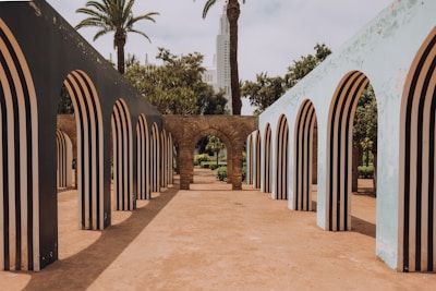 a walkway with arches and trees