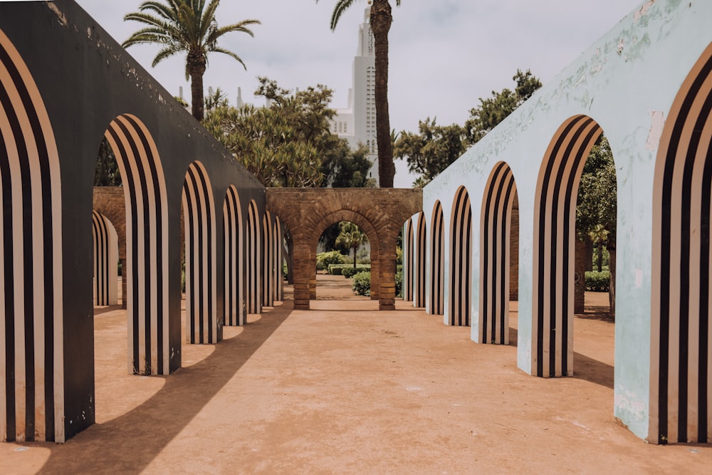 a walkway with arches and trees