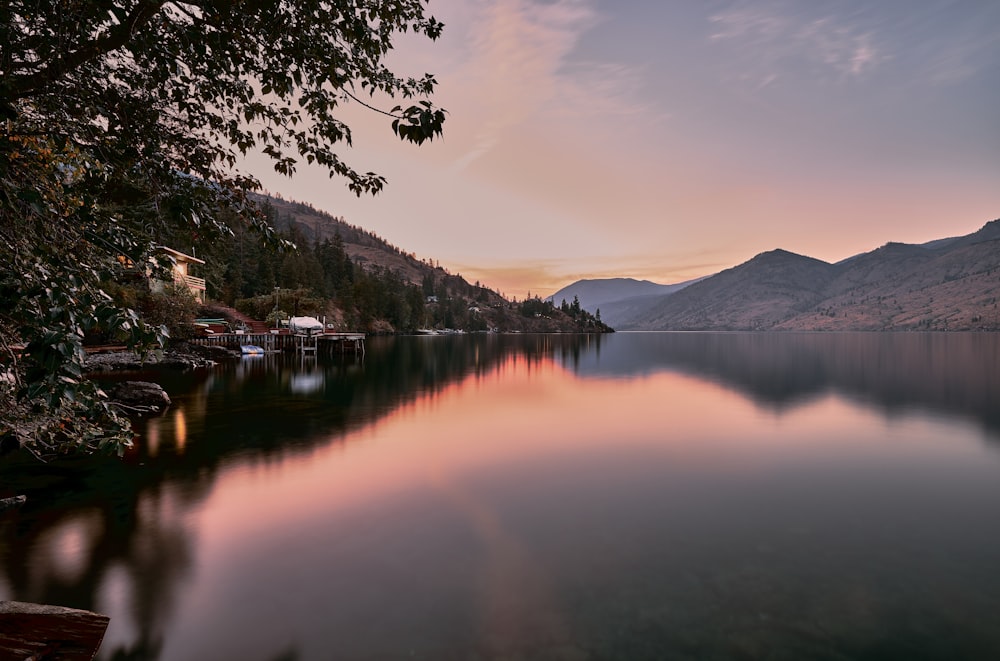 a lake with trees and mountains in the background