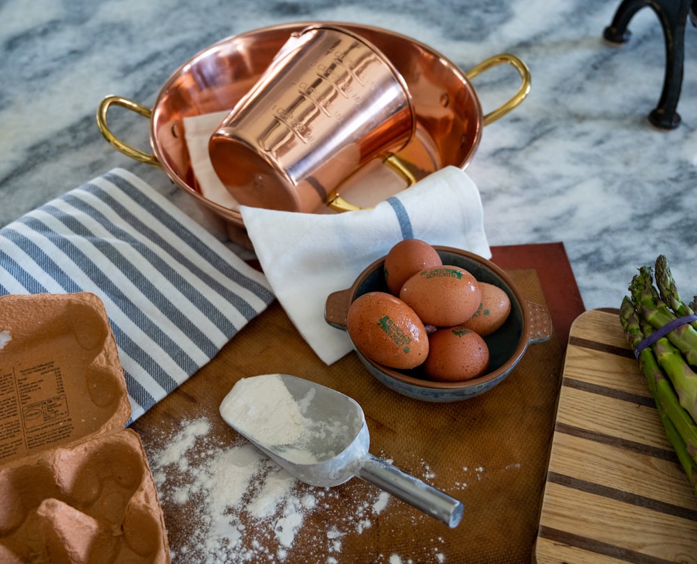 a basket of eggs and a bottle of tea on a table