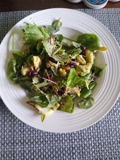 A fresh green salad with avocado slices, cherry tomatoes, and a light vinaigrette.