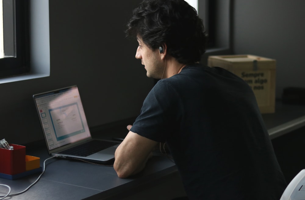 a man sitting at a desk with a laptop