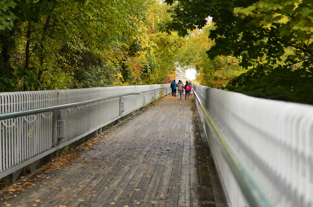 a group of people walking on a bridge