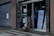 Two children are outside a building entrance with a sign indicating a kids' sale event scheduled for October 31, 2022. The building has a large, closed metal shutter, and the children are engaged in conversation or observation.
