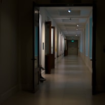A serene hospital corridor bathed in soft red lighting, evoking warmth and care.
