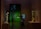 A dimly lit museum gallery featuring two sculptures; one large white sculpture on a pedestal and another golden sculpture casting a shadow on the wall. A person stands to the left, looking at their phone, while another person on the right is holding an object against a backdrop of a green-painted room with framed artwork.