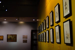 Sleek gallery wall showcasing colorful mixed-media pieces under soft lighting.