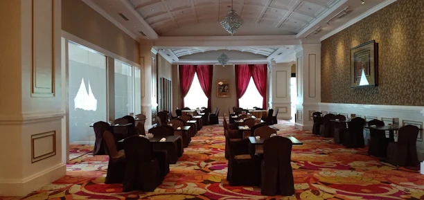A serene dining hall featuring floor-to-ceiling custom drapes that add warmth and style.