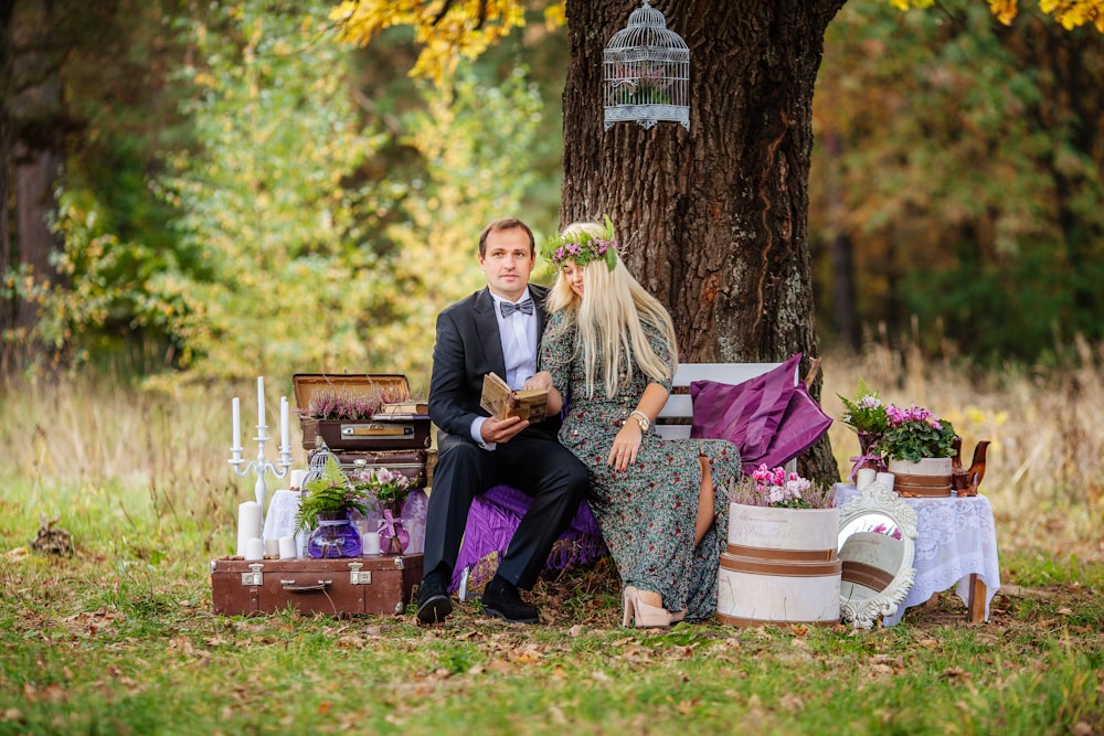 a man and woman sitting on a bench in a park