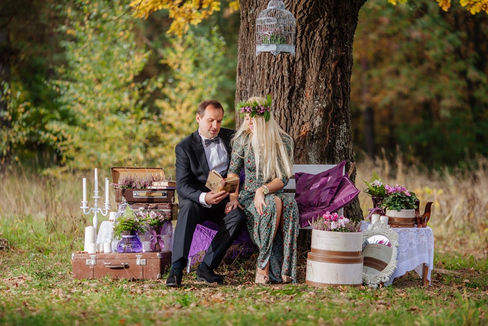 a man and woman sitting on a bench in a park