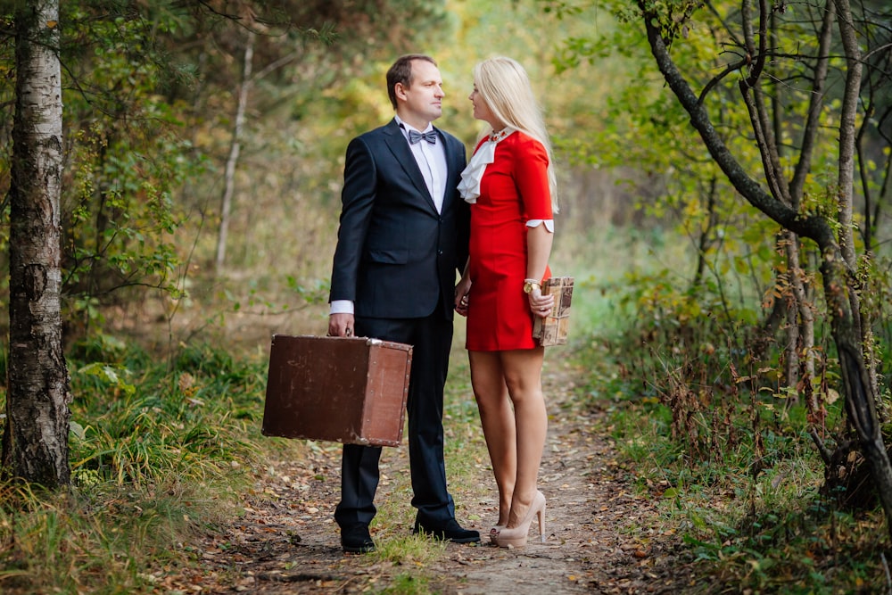 a man and woman walking on a path in the woods