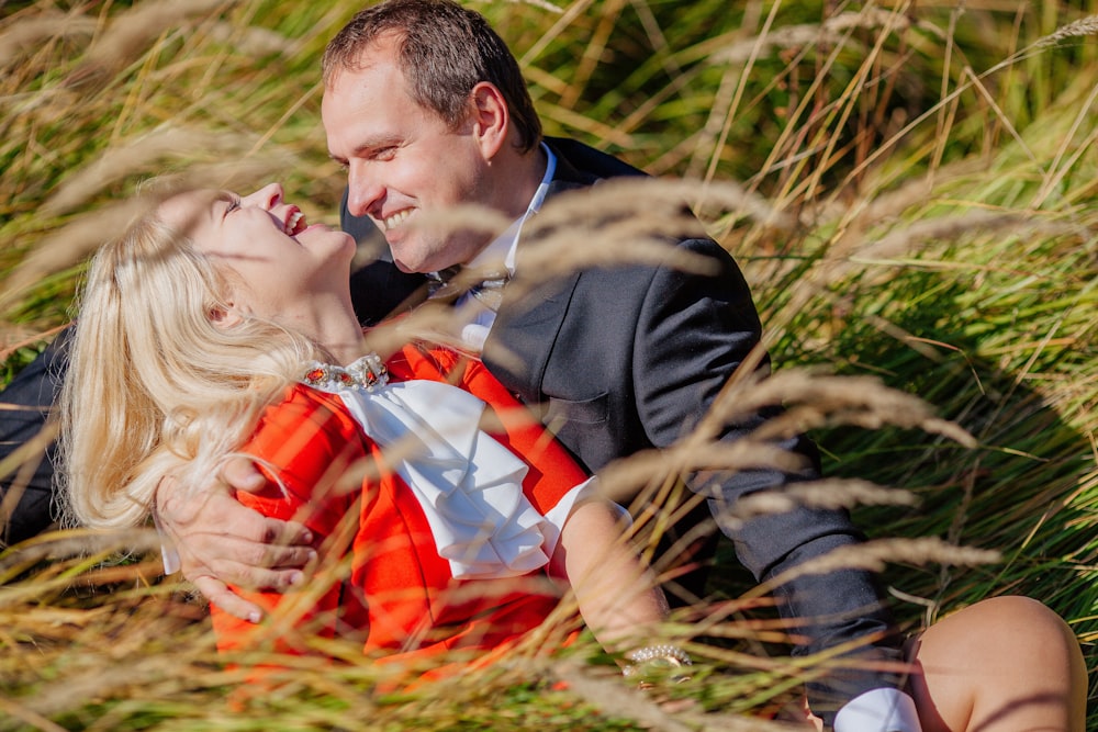 a man and a woman sitting in the grass