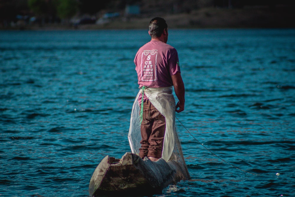 a man standing on a rock in the water