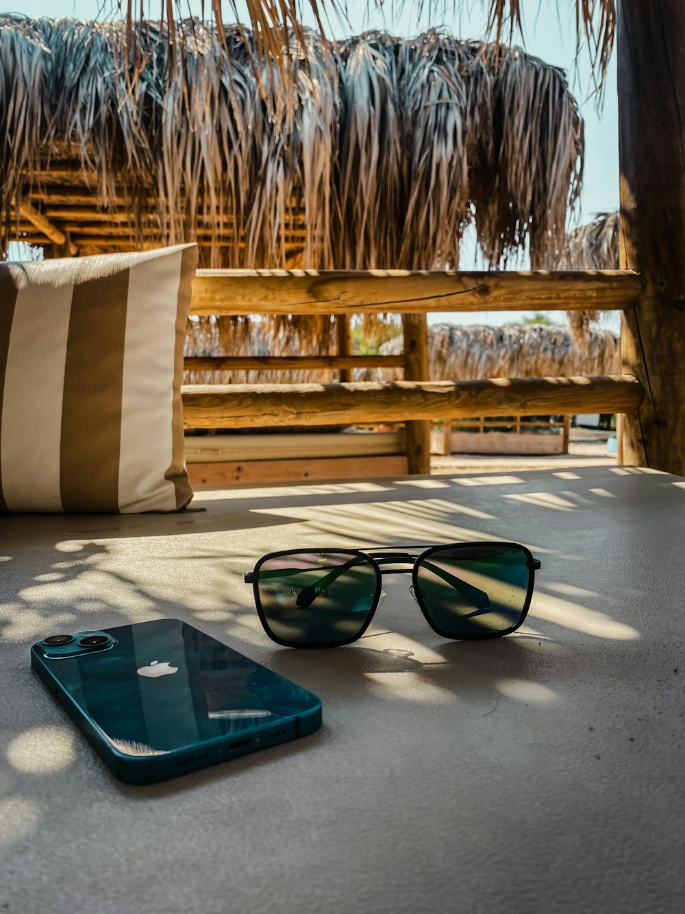 a laptop and sunglasses on a bench